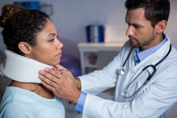 理学療法士が女性患者の首を調べる — ストック写真