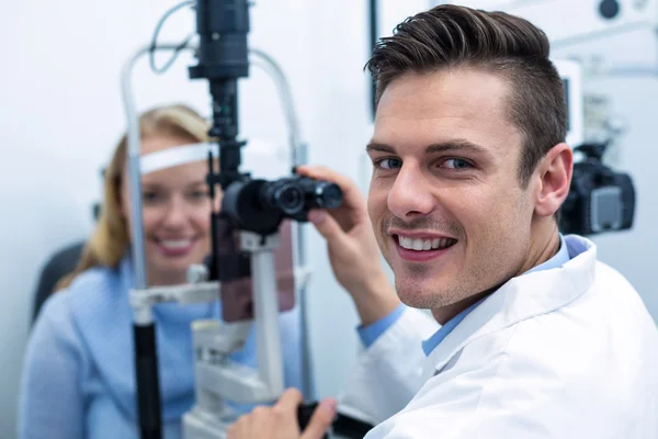 Optometrista examinando paciente feminina em lâmpada de fenda — Fotografia de Stock