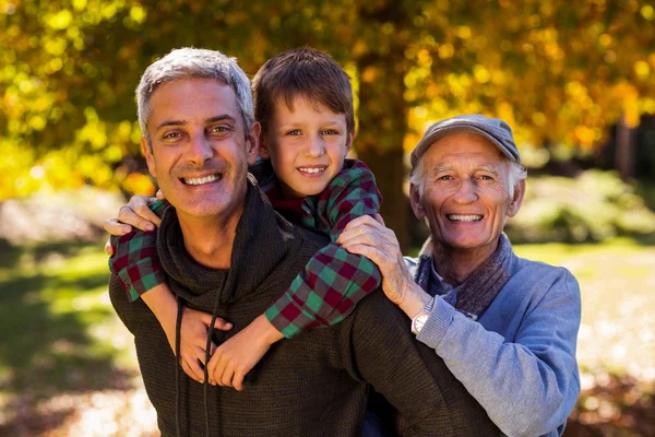 Man piggybacking son while with father — Stock Photo, Image