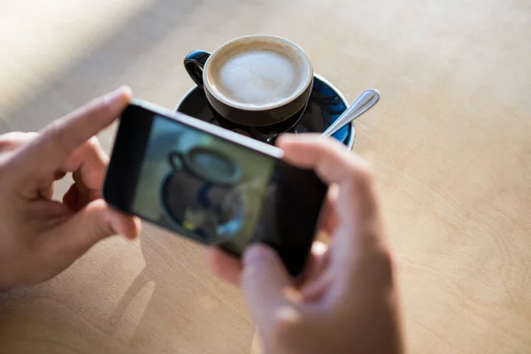 Manos femeninas fotografiando una taza de café — Foto de Stock