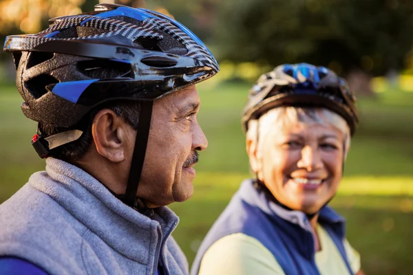 Maduro casal segurando ciclismo capacete — Fotografia de Stock