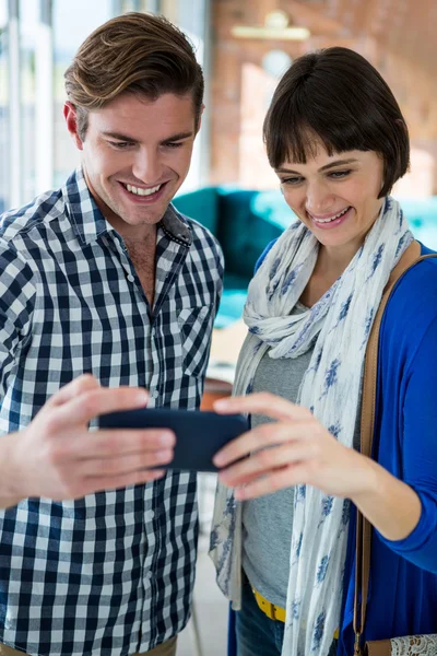 Lächelndes Paar schaut aufs Handy — Stockfoto