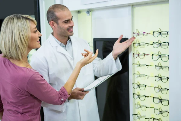 Augenoptiker berät Kunden über Brillen — Stockfoto