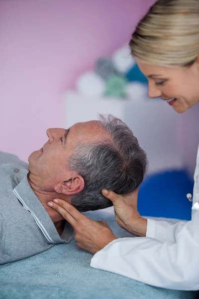 Starší muž přijímá masáž krku od fyzioterapeuta — Stock fotografie