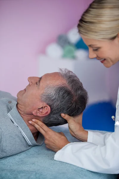 Senior mannen som fick nackmassage från sjukgymnast — Stockfoto