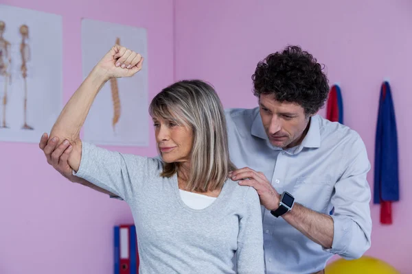 Fisioterapeuta dando masaje en el hombro al paciente — Foto de Stock