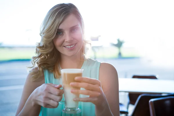 Retrato de una mujer sonriente sosteniendo una taza de café — Foto de Stock