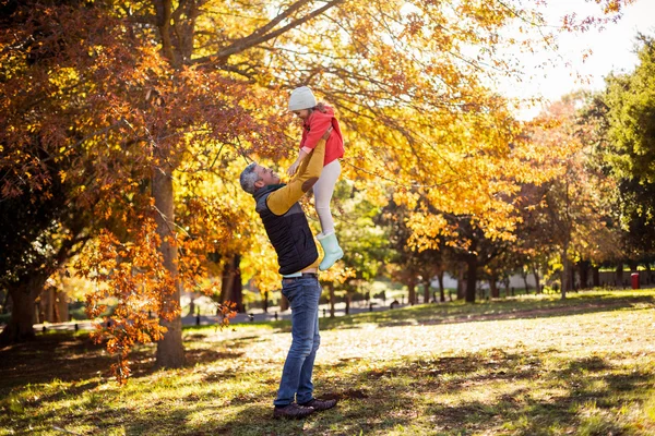 Padre sosteniendo hija en parque — Foto de Stock