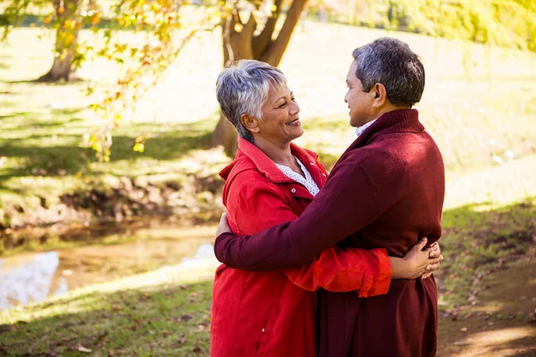 Pareja abrazando mientras de pie en el parque — Foto de Stock