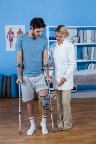 Fizjoterapeuta pomaga pacjentowi chodzić — Zdjęcie stockowe