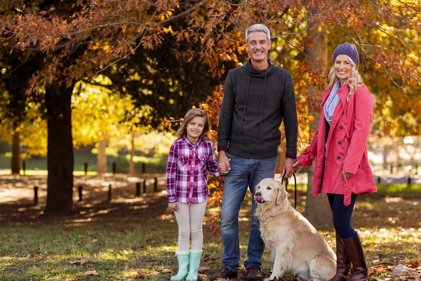 Família feliz com cão no parque — Fotografia de Stock