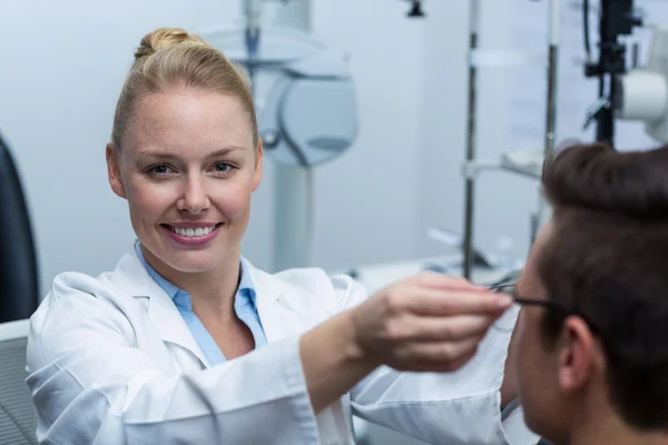 Kvinnliga optiker förskrivning glasögon till patient — Stockfoto