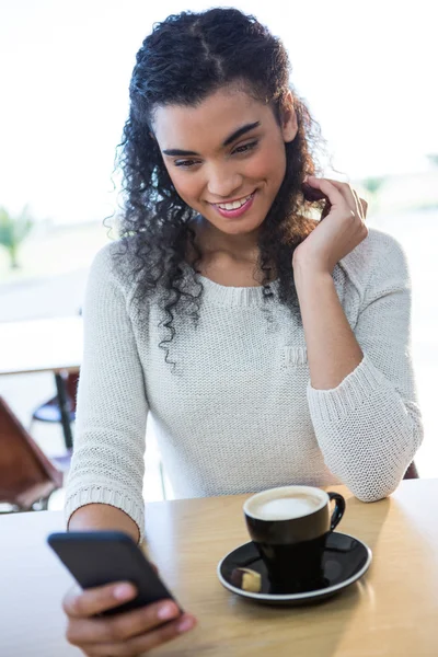 Mulher usando telefone celular e uma xícara de café — Fotografia de Stock