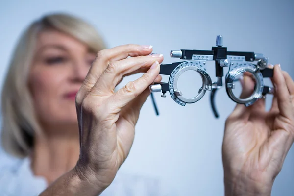 Augenoptikerin blickt auf Messbrille — Stockfoto