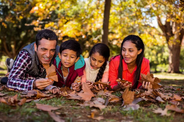 Familjen liggande på fältet under hösten — Stockfoto