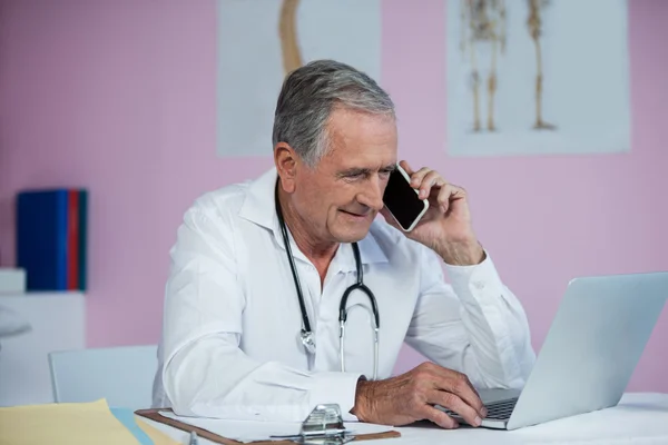 Physiotherapist talking on mobile phone — Stock Photo, Image