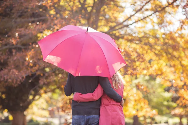 Coppia abbracciando mentre si tiene in mano l'ombrello — Foto Stock