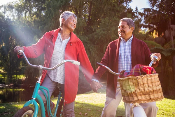 Casal maduro com bicicleta no parque — Fotografia de Stock