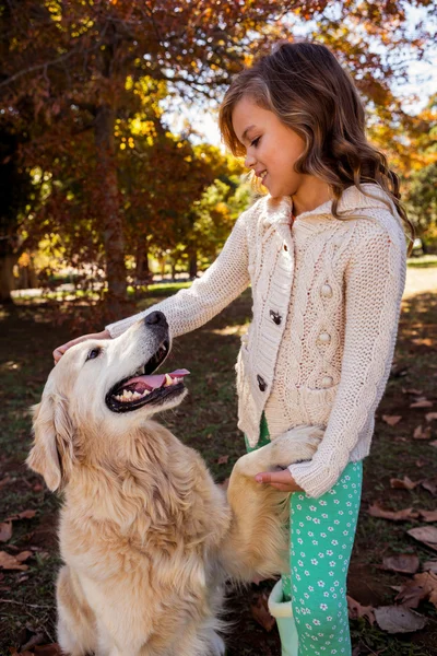 Perro dando su pata a una niña — Foto de Stock