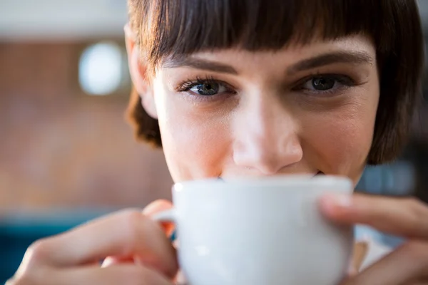 Frau trinkt Tasse Kaffee in Cafeteria — Stockfoto