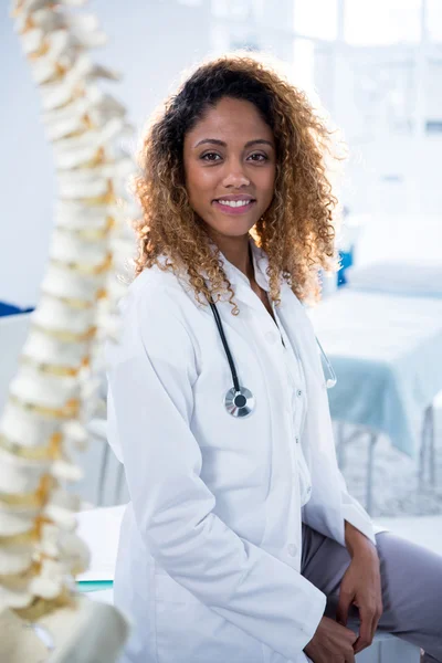 Lachende fysiotherapeut zitten in kliniek — Stockfoto