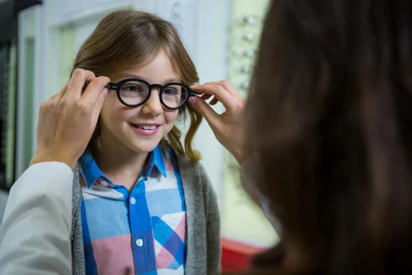 Kvinnliga optiker förskrivning glasögon till ung patient — Stockfoto