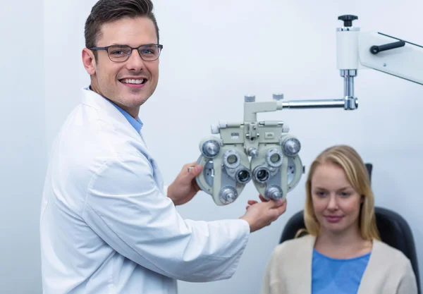 Optometrista sonriente examinando paciente femenino —  Fotos de Stock