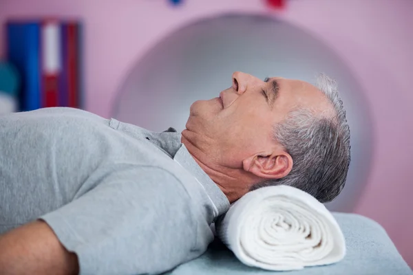 Senior man lying on a massage bed — Stock Photo, Image