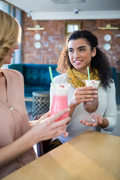 Amigos do sexo feminino tendo milkshake na cafetaria — Fotografia de Stock
