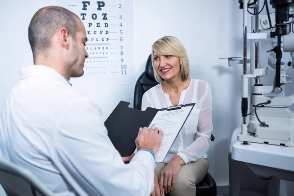 Optometrista do sexo masculino falando com paciente do sexo feminino — Fotografia de Stock