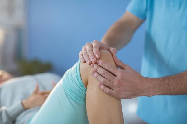 Sjukgymnasten ger knä massage till patient — Stockfoto