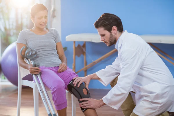 Fisioterapeuta examinando pacientes mujeres rodilla — Foto de Stock