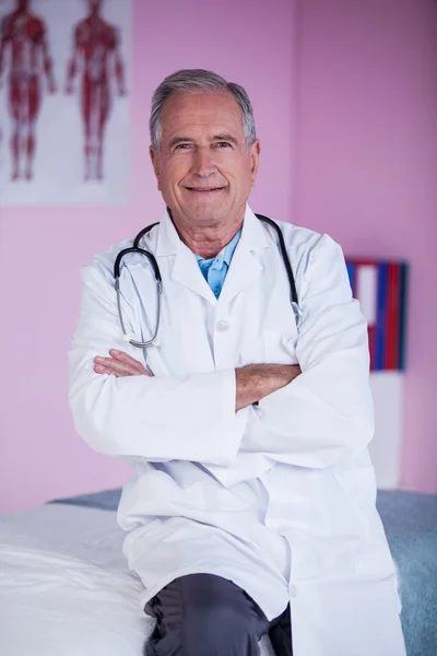 Portrét fyzioterapeut sedí s rukama zkříženýma — Stock fotografie