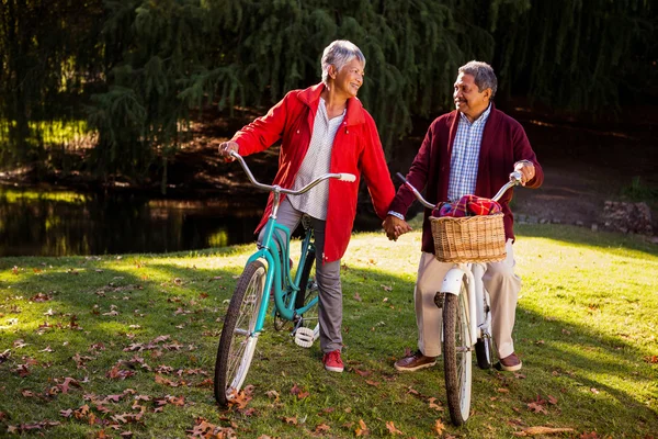 Pareja adulta con bicicleta en el parque — Foto de Stock