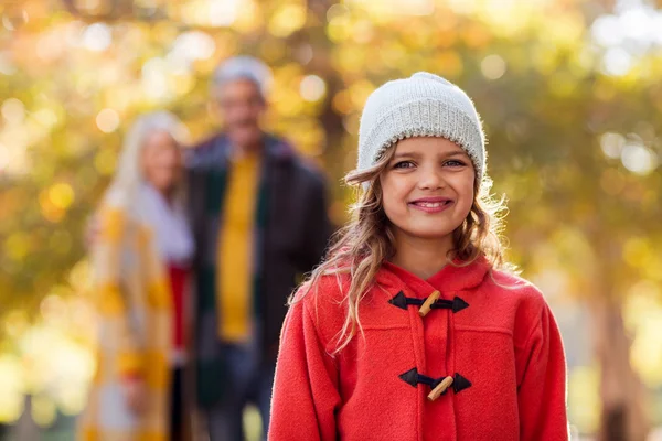 Sorridente ragazza con la famiglia in background — Foto Stock