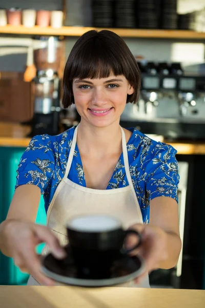 Portrét servírka nabízí šálek kávy — Stock fotografie