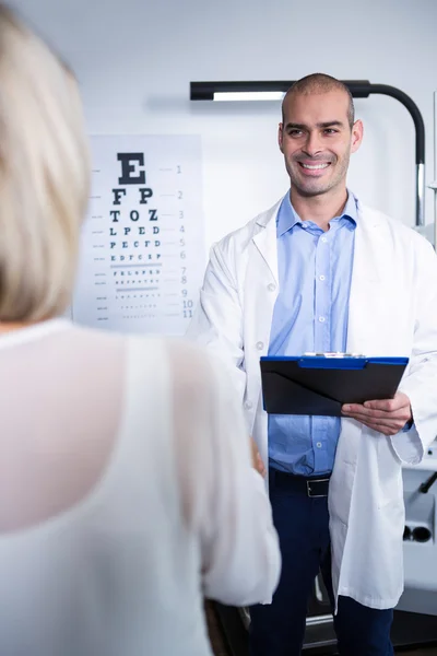 Optometrista masculino hablando con paciente femenino — Foto de Stock