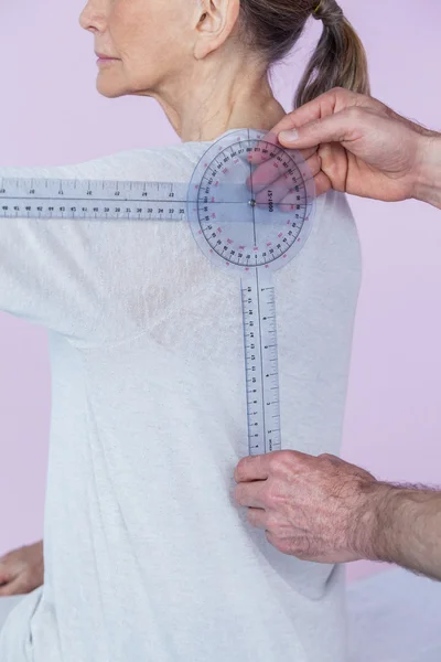 Fisioterapeuta medindo pacientes do sexo feminino de volta — Fotografia de Stock