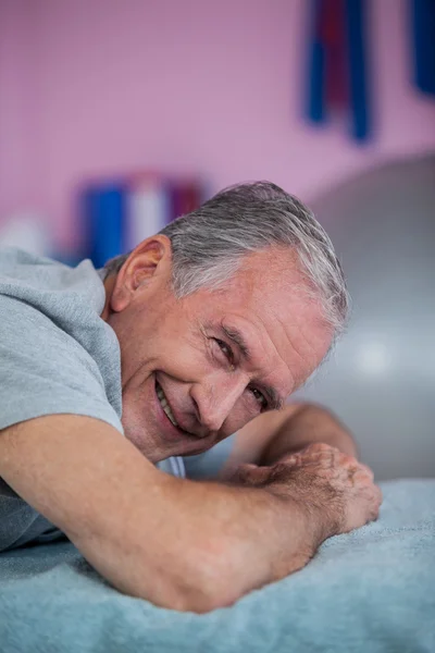 Portret van senior man liggend op een massagebed — Stockfoto