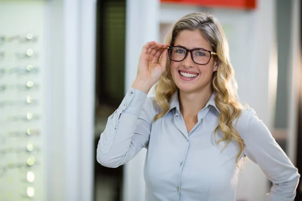 Uśmiecha się kobieta klienta próbuje okulary — Zdjęcie stockowe