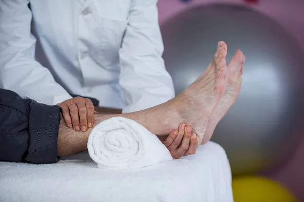 Hombre mayor recibiendo masaje de pies de fisioterapeuta —  Fotos de Stock