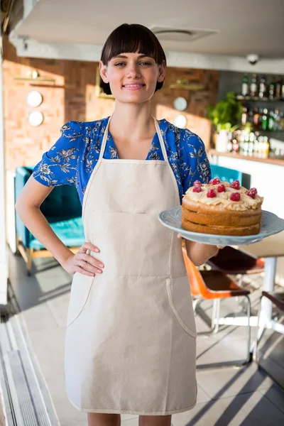 Portrét usměvavá servírka drží dort — Stock fotografie