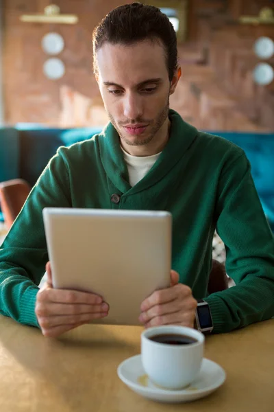 Ο άνθρωπος χρησιμοποιώντας ψηφιακό tablet και φλιτζάνι καφέ στο τραπέζι — Φωτογραφία Αρχείου
