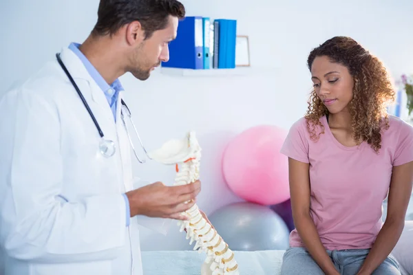 Fisioterapista che spiega il modello della colonna vertebrale al paziente — Foto Stock