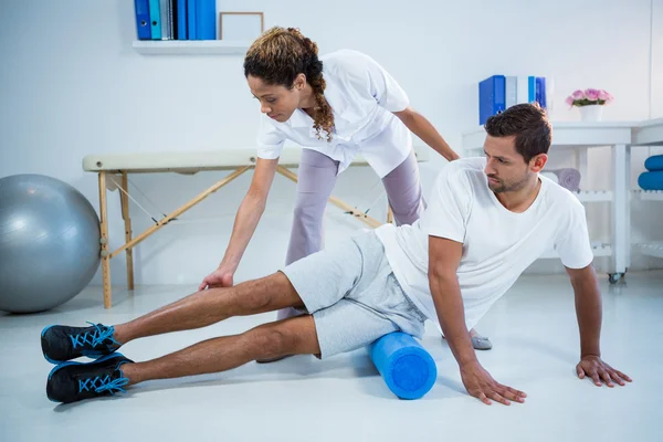 Physiotherapist doing leg therapy to a man — Stock Photo, Image
