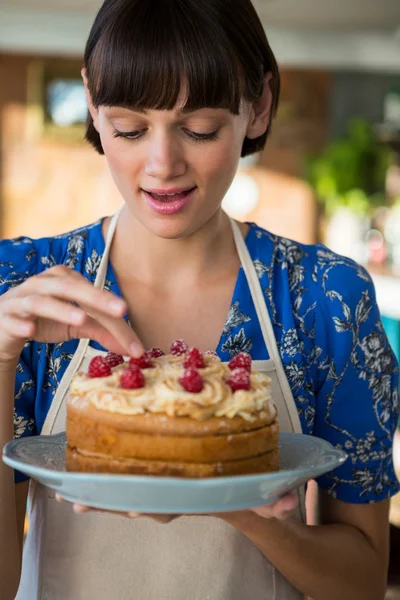 Camarera tocando la cereza en la tapa de la torta — Foto de Stock