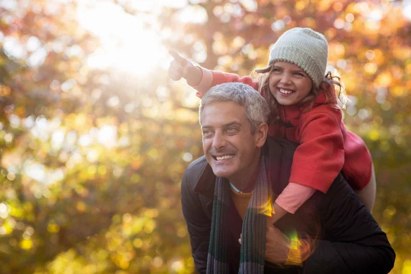 Père piggyback fille contre les arbres d'automne — Photo