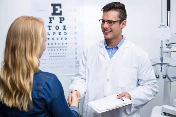 Optometrist schudden handen met vrouwelijke patiënt — Stockfoto