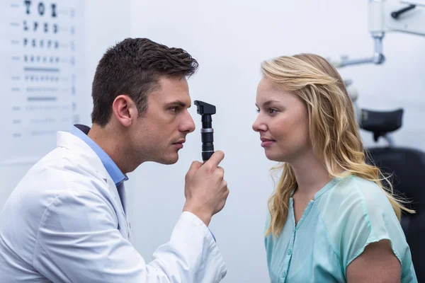 Augenoptiker untersucht Patientin durch Ophthalmoskop — Stockfoto