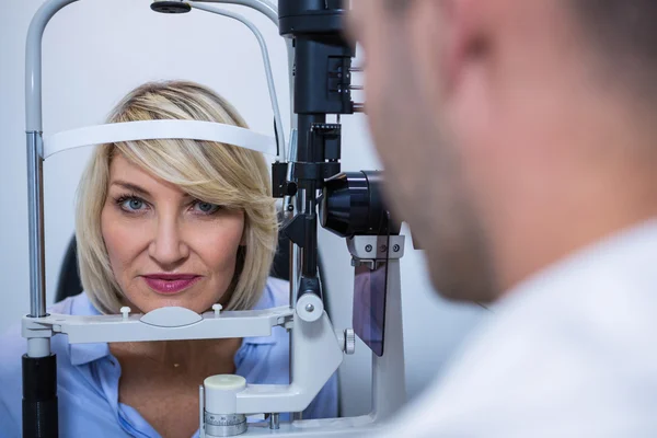 Optometrista examinando paciente feminina em lâmpada de fenda — Fotografia de Stock